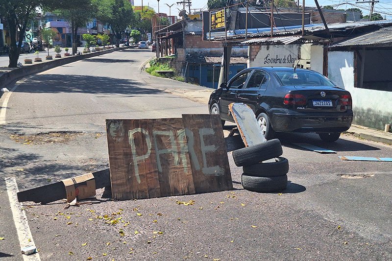 Moradores improvisaram para alertar sobre buracos na via (Foto: Josemar Antunes) Moradores interditam rua por buracos “invisíveis” ao prefeito de Manaus