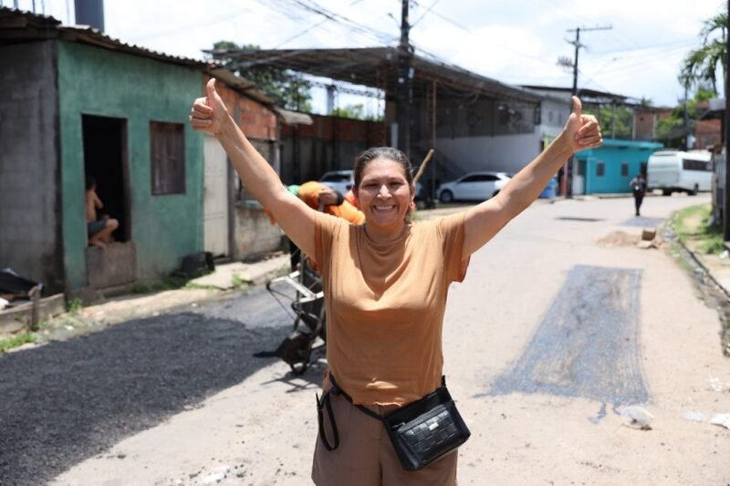 Moradora comemora a recuperação da via onde mora. (foto: Márcio Melo/Seminf)